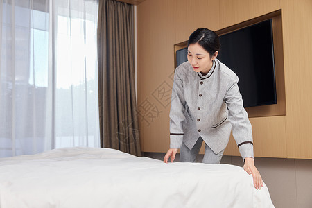 酒店服务保洁员整理客房床铺背景图片