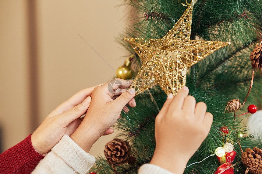 装饰圣诞树的儿童特写图片
