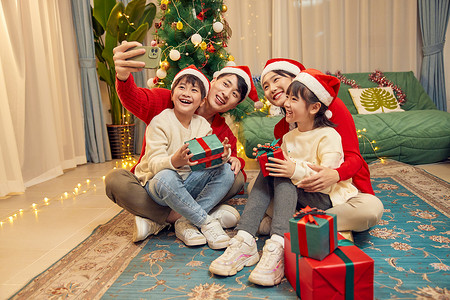 三个礼物盒圣诞节一家四口使用手机合照背景