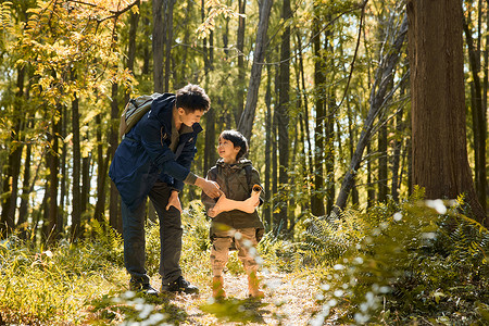 爸爸带儿子在丛林徒步探险高清图片