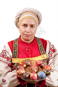穿着俄罗斯传统服装和帽子的妇女拿着东图片