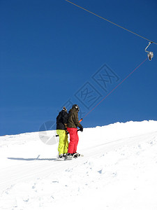 型滑雪缆车上的两名滑雪板运动员图片