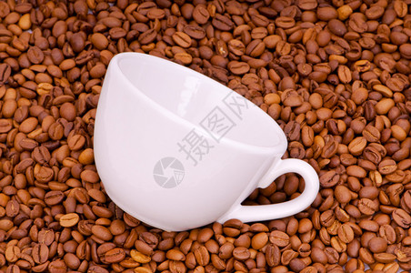 咖啡豆背景上的白色杯子图片