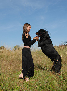 微笑的青少年和她的大黑狗图片