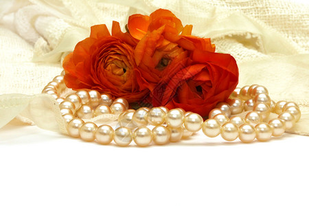 花朵和珍珠放在精细的蕾丝和白背景图片