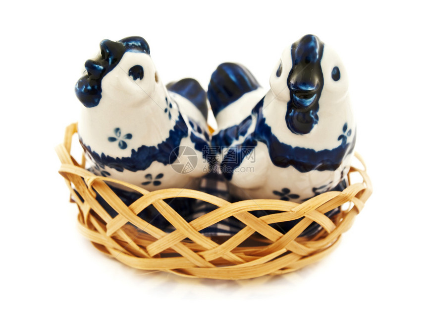 两只瓷鸡在白色背景的木篮子图片