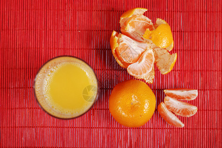 杯橙汁和橘子在红色背景图片