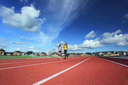 两个女孩在体育场奔跑广角图片