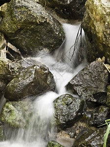 流动的泉水从岩石和头中渗出图片