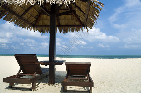 带小屋和椅子的热带海滩图片