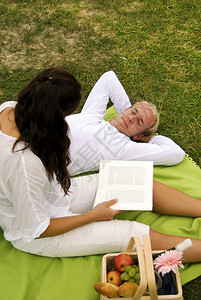 一位年轻女子在一次浪漫野餐期间向英俊的图片