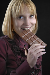 女孩拿着巧克力棒在黑暗图片