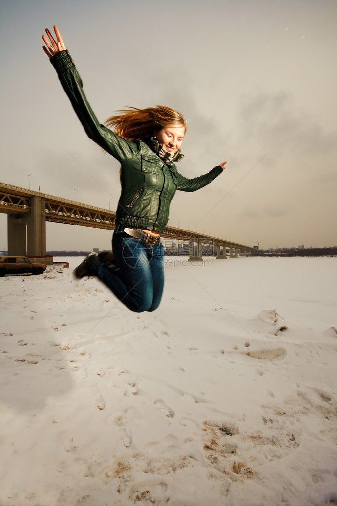 女人在户外雪地里跳跃图片