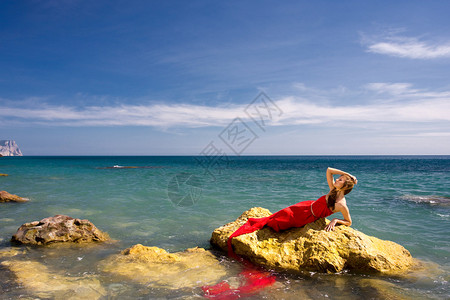 海边沙滩上穿红裙子的美女图片