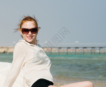 美丽的红衣女子在海边晒太阳图片