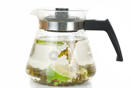 在白色背景上隔离的带绿茶的水壶图片