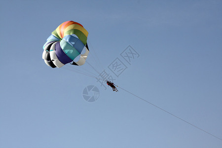 在蓝天上跳伞的色彩多的寄生虫的图片