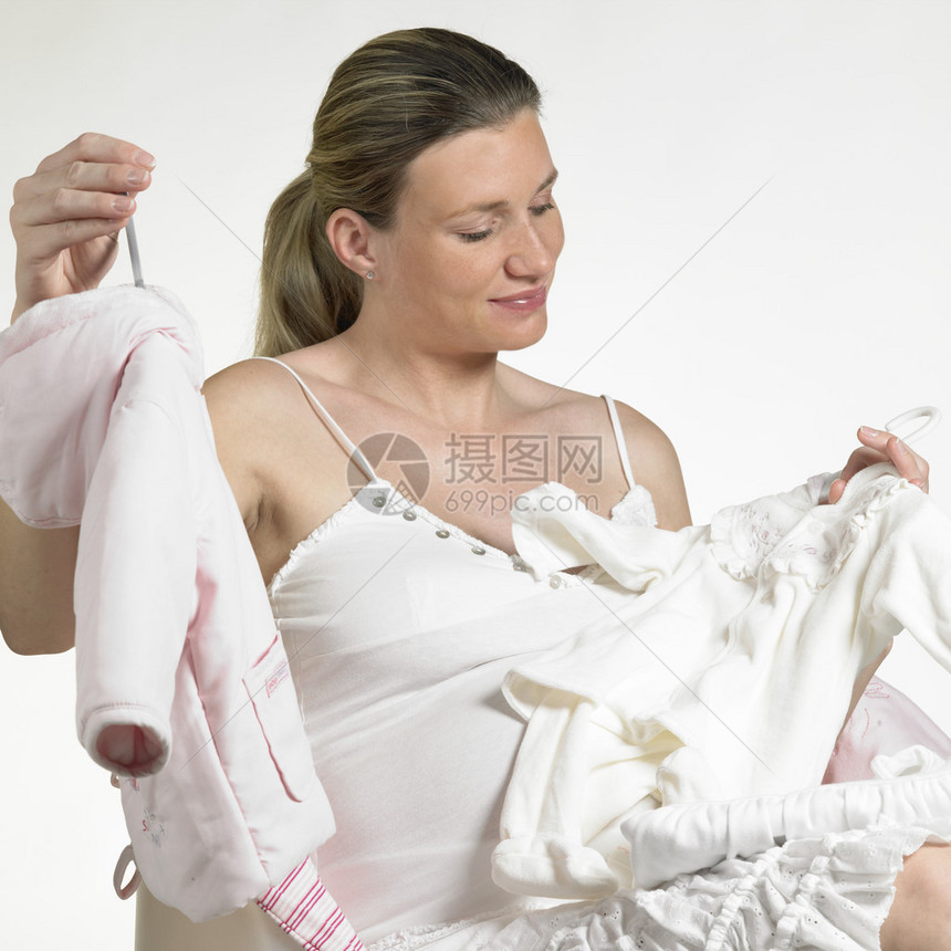 有婴儿衣服的孕妇图片