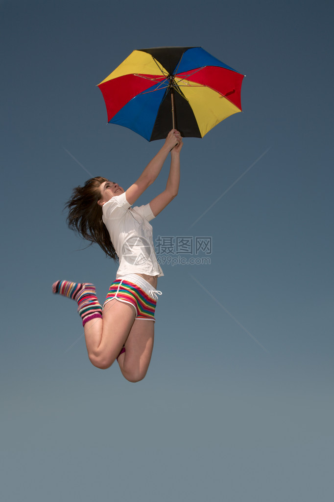 打着彩色伞的女孩高地往上跳图片