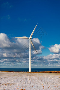 蓝色大海和明亮的天空背景上的现代风车图片