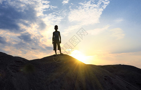 年轻人在日落剪影的沙漠中上去高清图片
