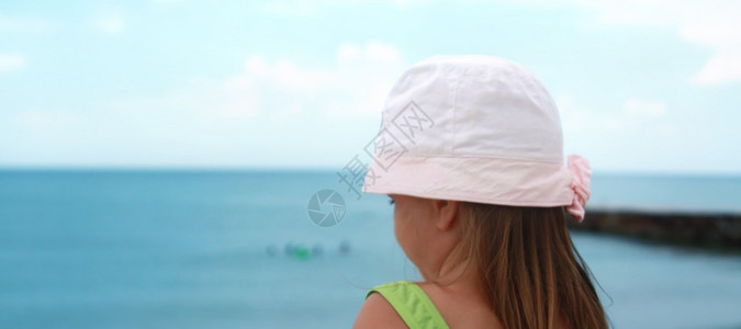 小女孩从海滩向外看海背图片