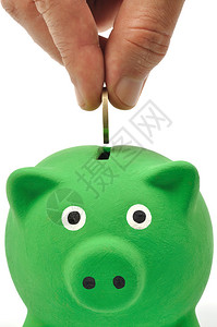 将硬币插入绿色存钱罐的手图片