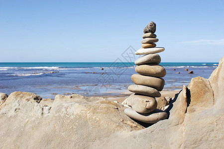 一堆平衡的石头背景是海滩图片