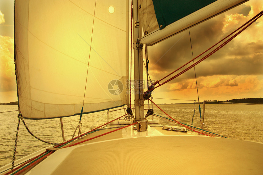 以日落为背景的帆船下帆图片