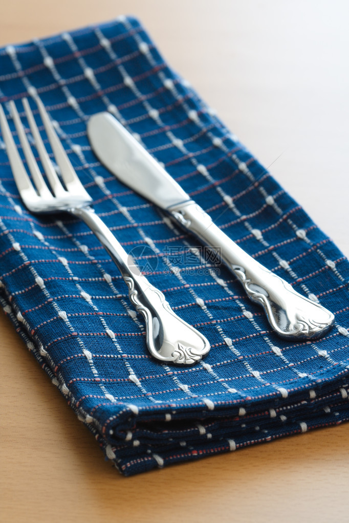 蓝色桌布上的叉子和刀图片