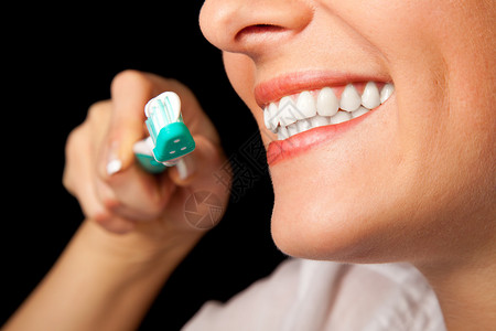妇女健康牙齿用黑色的牙刷图片