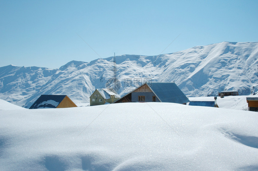 冬天雪下的高山和房屋图片