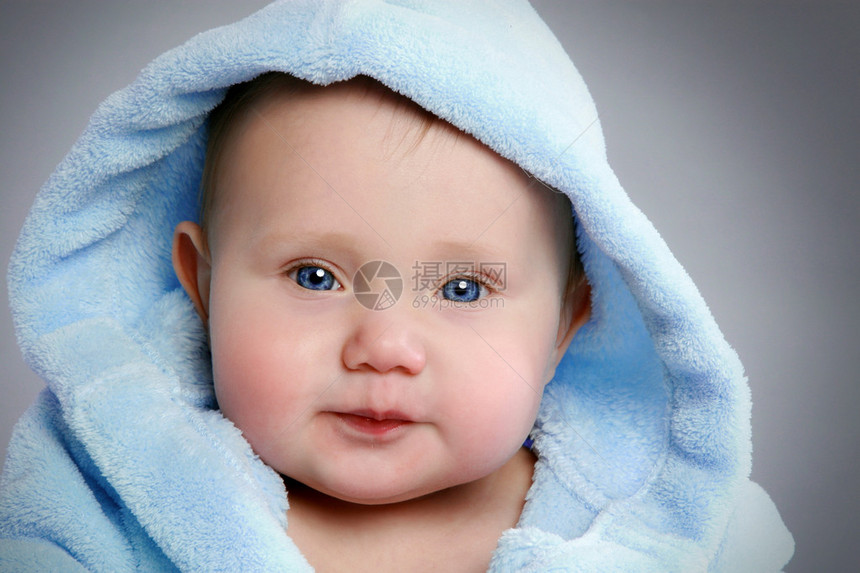 穿着灰色背景的蓝色柔软小羊皮可爱婴图片