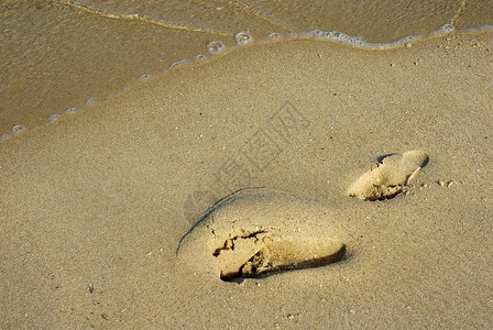 沙滩上的脚印和波浪图片
