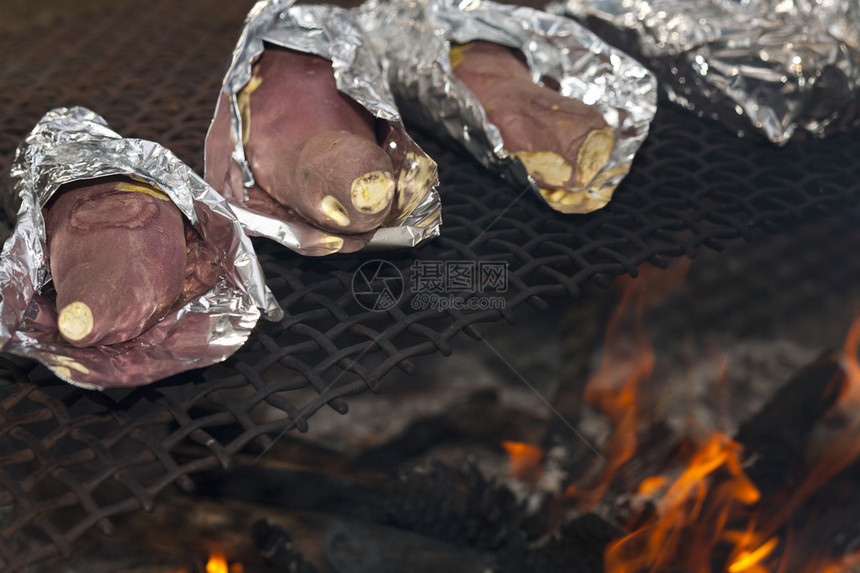 用铝箔包裹的红薯正在明火上煮熟图片