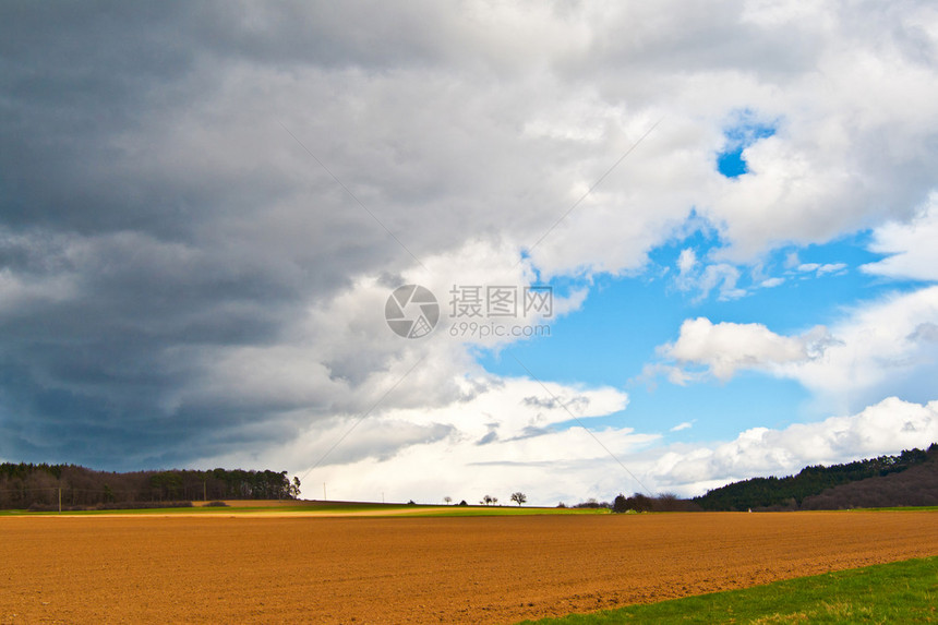 田野上空的乌云和蓝天图片