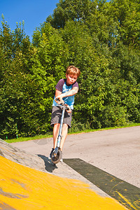 男孩在滑板公园骑摩图片