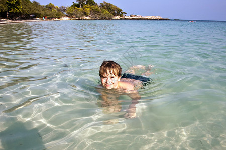 男孩在美妙温暖的海洋中玩得图片