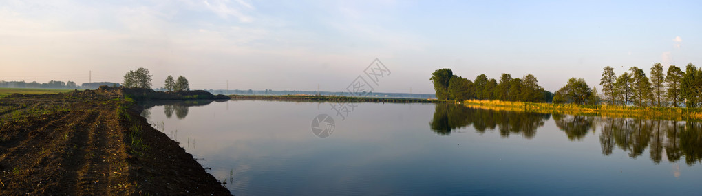 一个乡村小湖和一片绿色森林图片