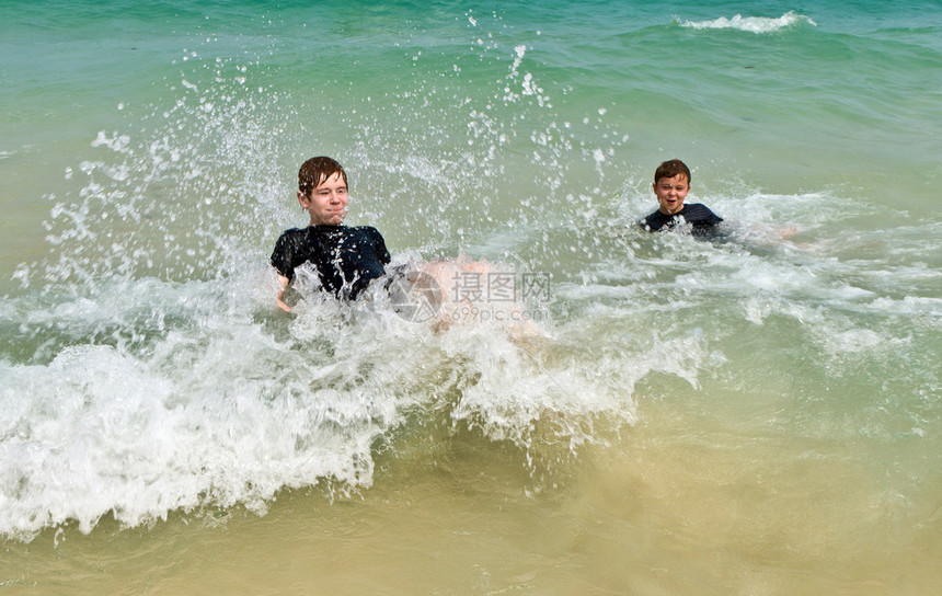 两个男孩在温暖的海图片