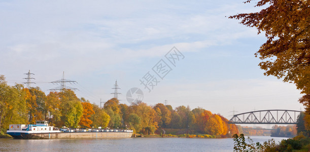 在秋天色的风景中停泊在运河上的德国货船背景图片