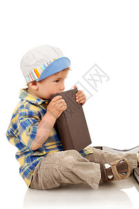 小男孩坐着拿一本书图片