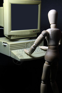 一个在旧电脑上工作的人形机器人图片