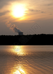 日落时湖上的一座运转良好的核电站高清图片