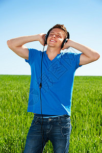 在耳机中微笑的男子欢乐地聆听音乐对图片