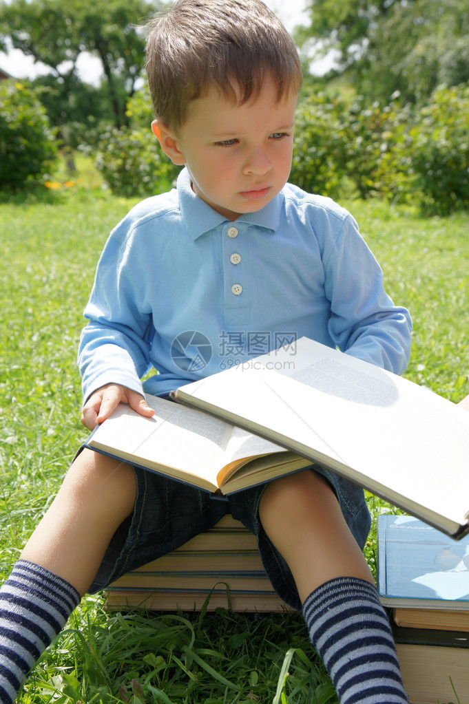 小男孩读一本书和思考图片