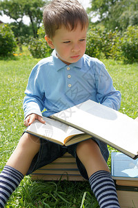 小男孩读一本书和思考图片