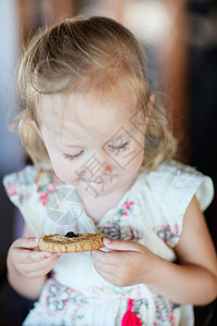 可爱的小女孩吃饼干的肖像图片