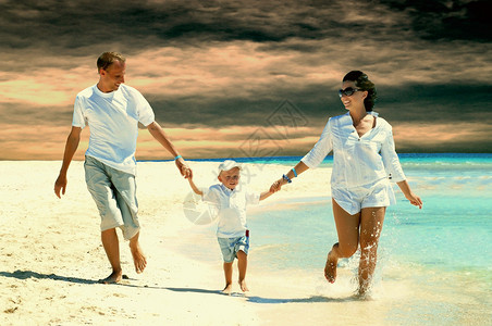 快乐的年轻家庭在海滩图片