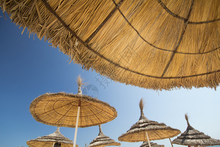 稻草沙滩伞配蓝天图片